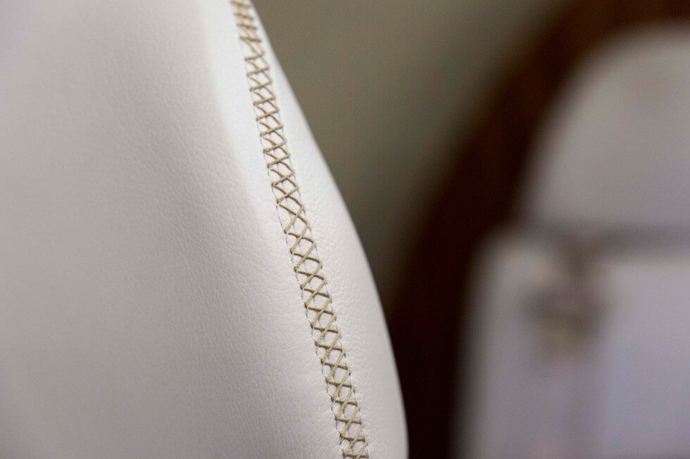 Hand-stitched leather seats in Phenom 300 aircraft refurbishment