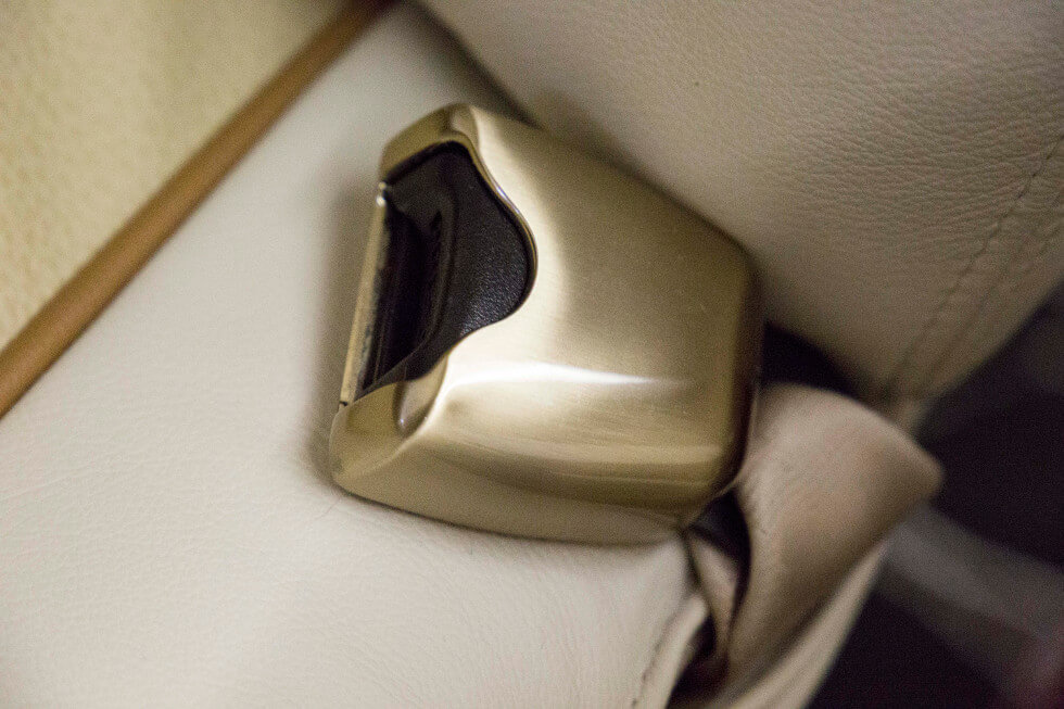 Seat belt buckle close-up in Phenom 300 aircraft refurbishment